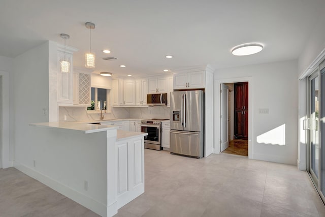 kitchen featuring stainless steel appliances, kitchen peninsula, decorative light fixtures, decorative backsplash, and white cabinets