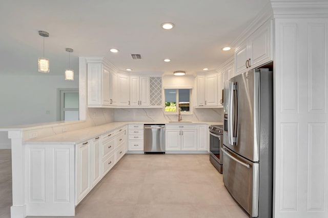 kitchen featuring white cabinetry, kitchen peninsula, hanging light fixtures, and appliances with stainless steel finishes