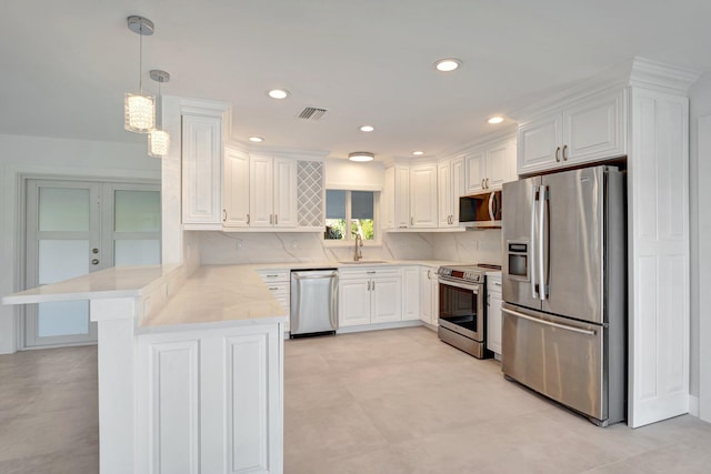 kitchen featuring pendant lighting, white cabinets, sink, kitchen peninsula, and stainless steel appliances