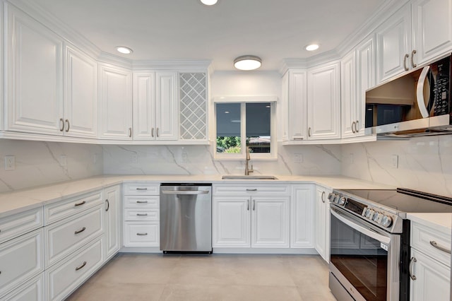 kitchen with white cabinetry, sink, stainless steel appliances, light stone counters, and backsplash