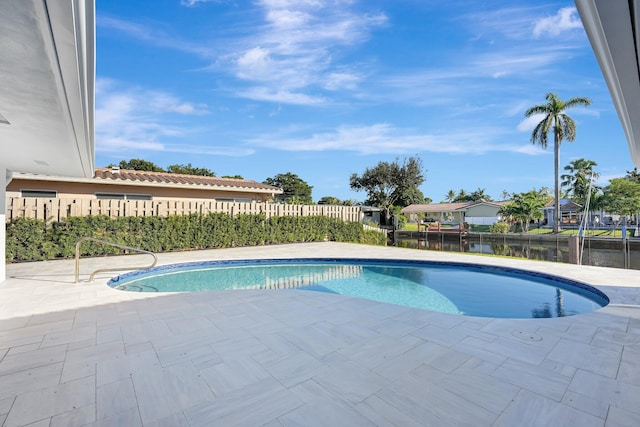 view of pool featuring a patio and a water view