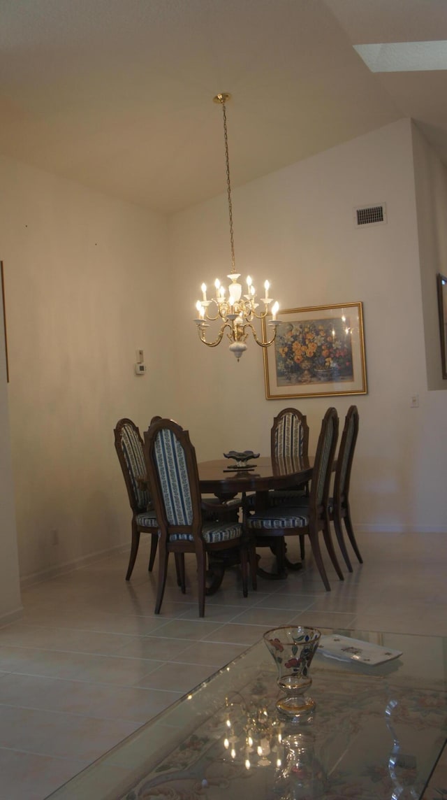 tiled dining space with a chandelier