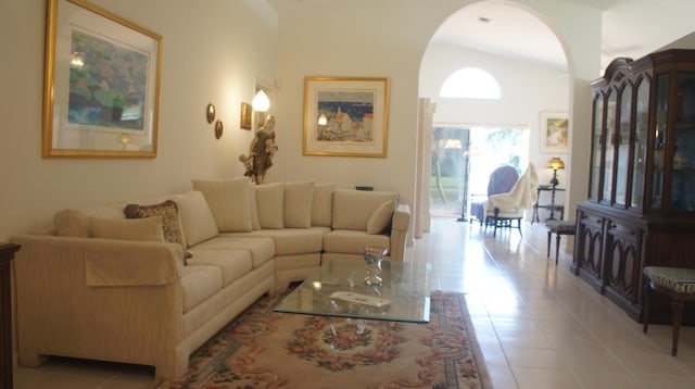 living room with light tile patterned floors and lofted ceiling