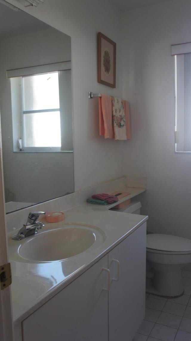 bathroom featuring tile patterned flooring, vanity, and toilet