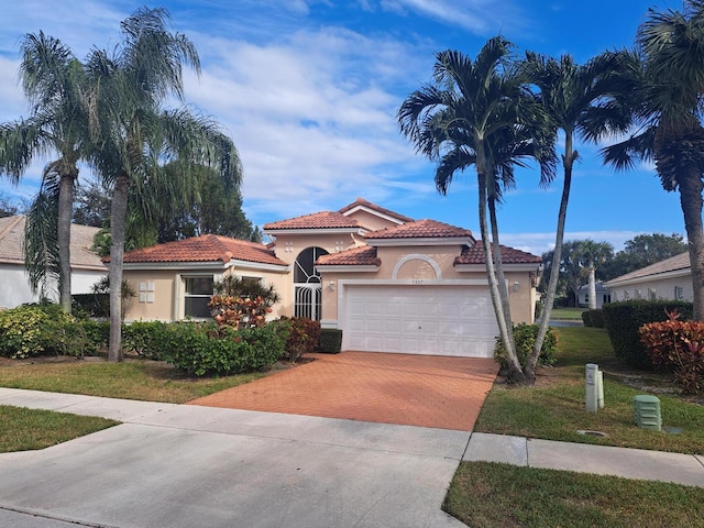 mediterranean / spanish house with a front lawn and a garage