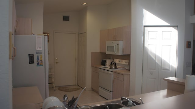 kitchen with light tile patterned floors and white appliances