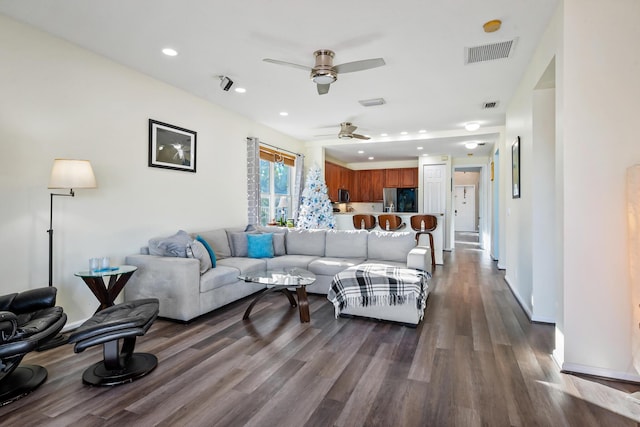 living room featuring ceiling fan and dark wood-type flooring