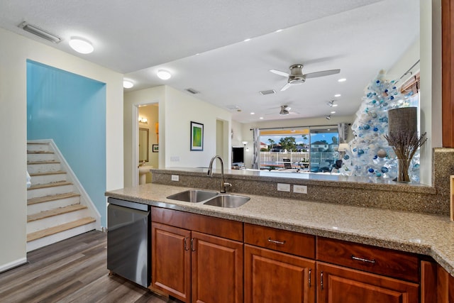 kitchen with dishwasher, dark wood-type flooring, sink, ceiling fan, and light stone counters