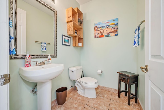 bathroom with toilet, tile patterned floors, and sink