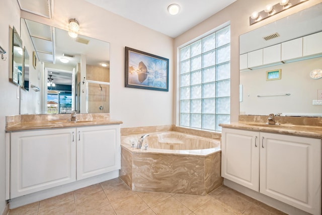 bathroom with tile patterned floors, separate shower and tub, vanity, and a healthy amount of sunlight