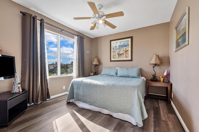 bedroom with dark hardwood / wood-style flooring and ceiling fan