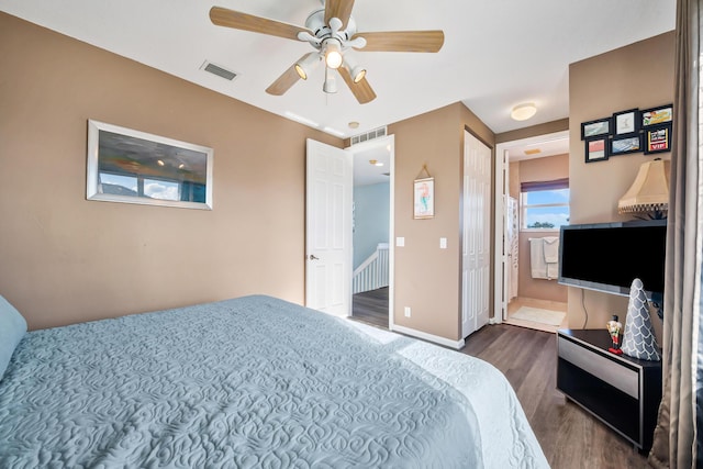 bedroom with ensuite bathroom, dark hardwood / wood-style flooring, and ceiling fan