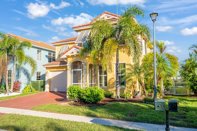 mediterranean / spanish-style house featuring a garage and a front yard