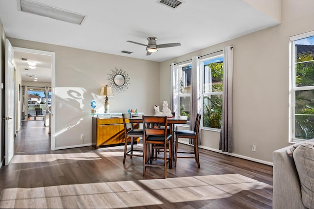 dining space with ceiling fan and dark wood-type flooring