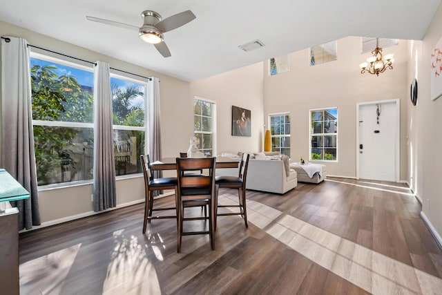 dining space featuring dark hardwood / wood-style flooring and ceiling fan with notable chandelier