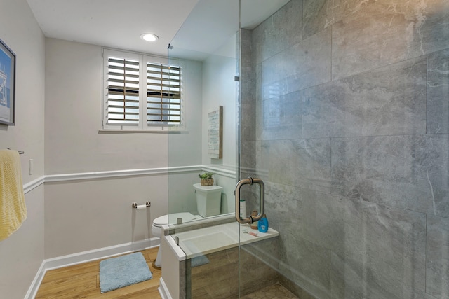 bathroom with walk in shower, toilet, and hardwood / wood-style flooring