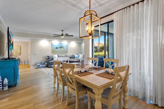 dining room featuring ceiling fan with notable chandelier, light wood-type flooring, and crown molding