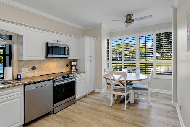 kitchen with white cabinetry, light hardwood / wood-style flooring, appliances with stainless steel finishes, and dark stone counters