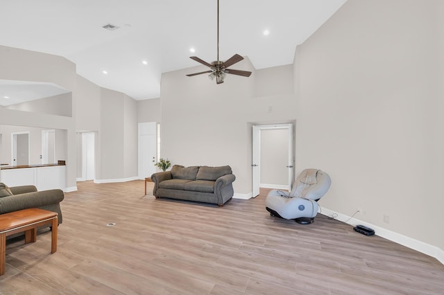 living room with ceiling fan, light hardwood / wood-style flooring, and high vaulted ceiling