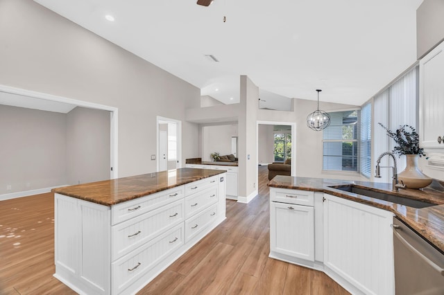 kitchen with dishwasher, white cabinetry, sink, and decorative light fixtures