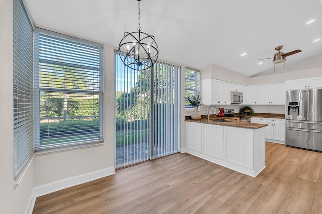 kitchen with kitchen peninsula, hanging light fixtures, a healthy amount of sunlight, white cabinetry, and stainless steel appliances