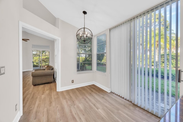 dining space with light wood-type flooring and a notable chandelier