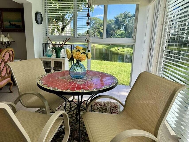 sunroom featuring a water view