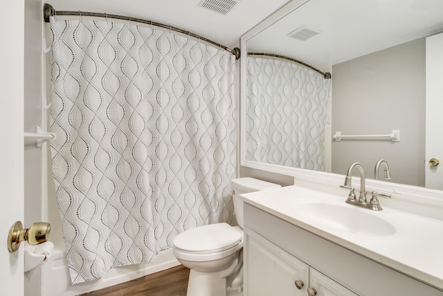 full bathroom with hardwood / wood-style floors, vanity, toilet, and shower / bath combo with shower curtain