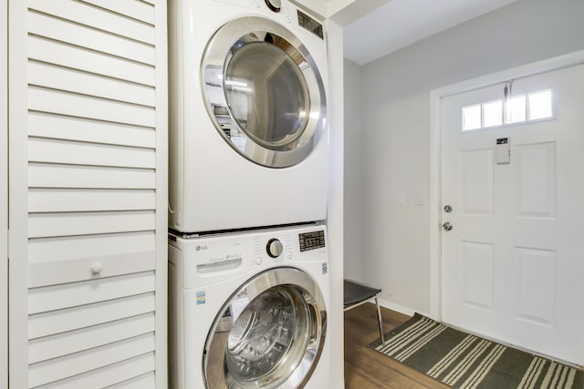 washroom featuring stacked washer / dryer and dark hardwood / wood-style floors