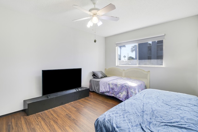 bedroom featuring ceiling fan, dark hardwood / wood-style floors, and a textured ceiling