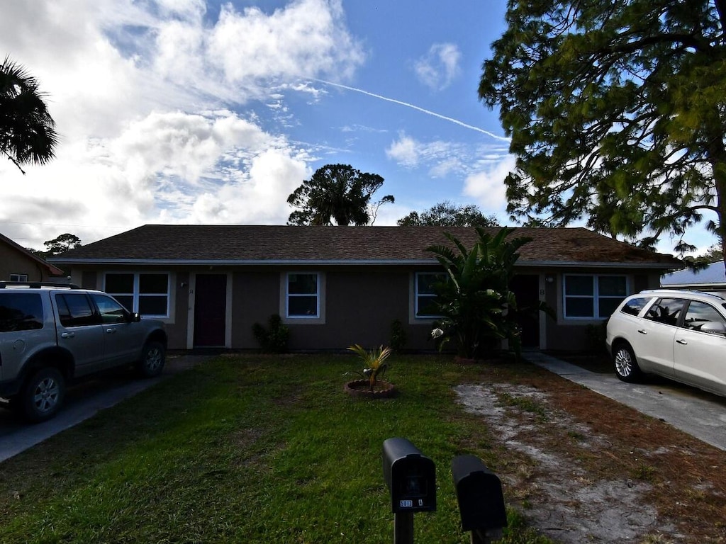 single story home featuring a front lawn