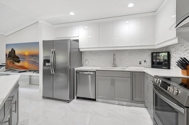 kitchen with sink, gray cabinets, decorative backsplash, appliances with stainless steel finishes, and ornamental molding