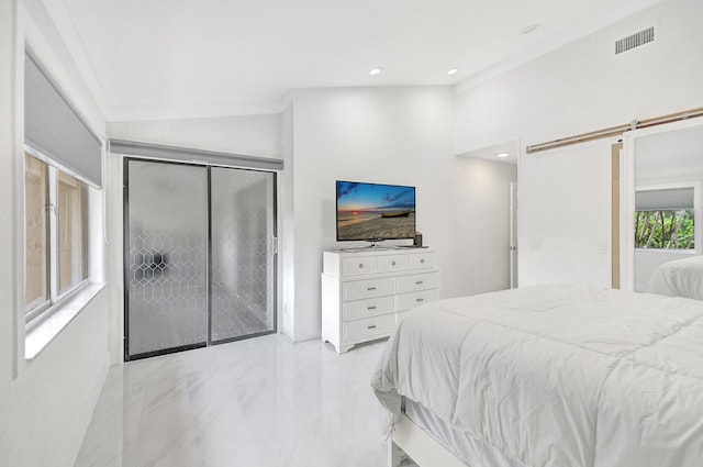 bedroom featuring a barn door, vaulted ceiling, and a closet