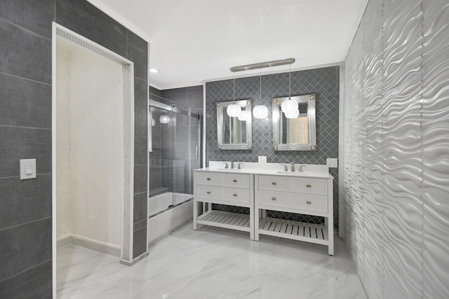 bathroom with vanity, bath / shower combo with glass door, and tile walls