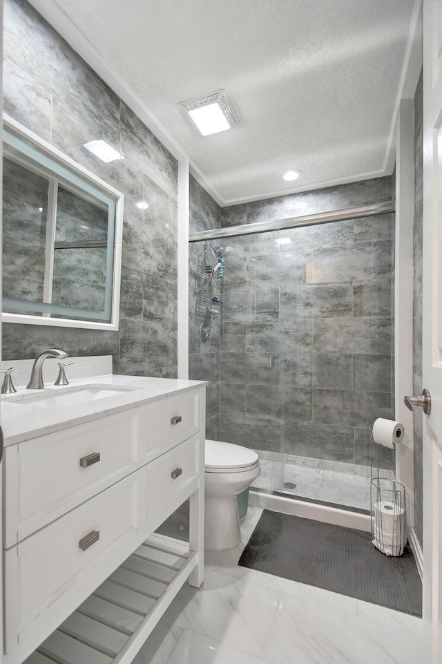 bathroom featuring a shower with door, vanity, a textured ceiling, and toilet