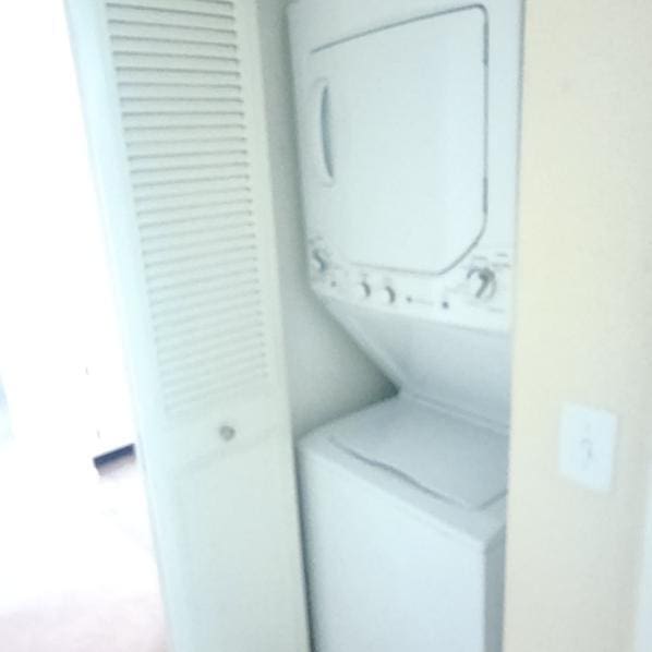 laundry room with stacked washing maching and dryer