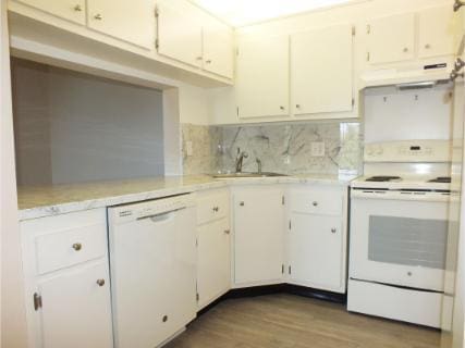 kitchen with white cabinets, light wood-type flooring, white appliances, and extractor fan