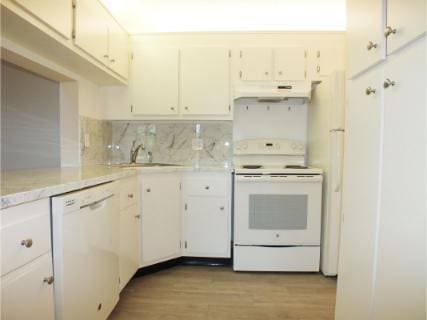 kitchen with white appliances, white cabinets, sink, light wood-type flooring, and tasteful backsplash