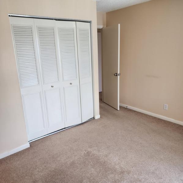 unfurnished bedroom featuring light carpet and a closet