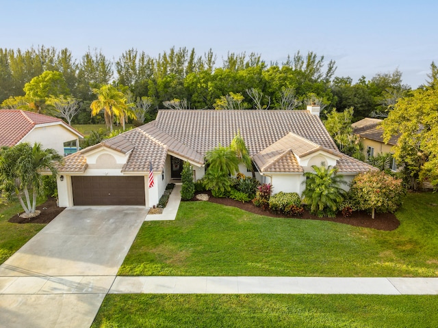 mediterranean / spanish home featuring a garage and a front lawn