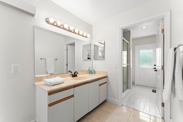 bathroom with tiled tub, tile patterned flooring, and vanity