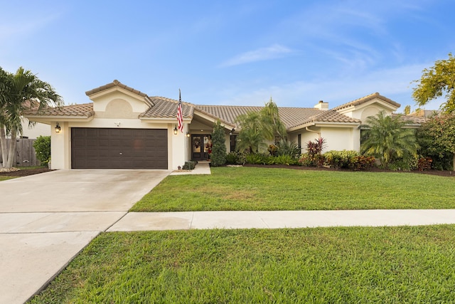 mediterranean / spanish-style house featuring a front yard and a garage