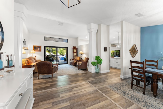 living room featuring ornate columns and hardwood / wood-style flooring