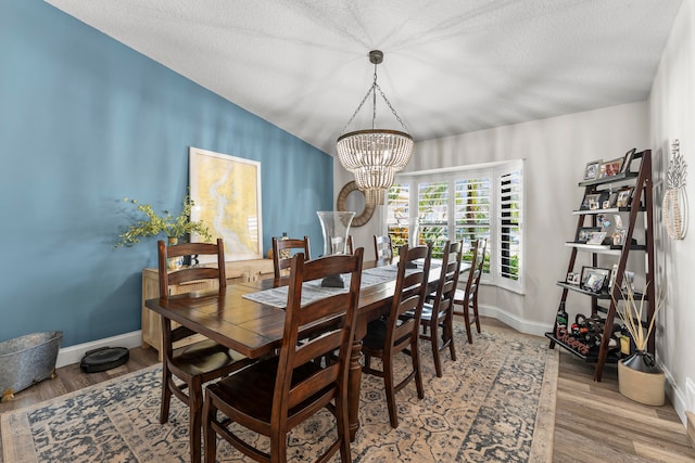 dining space featuring hardwood / wood-style flooring, a textured ceiling, and a chandelier