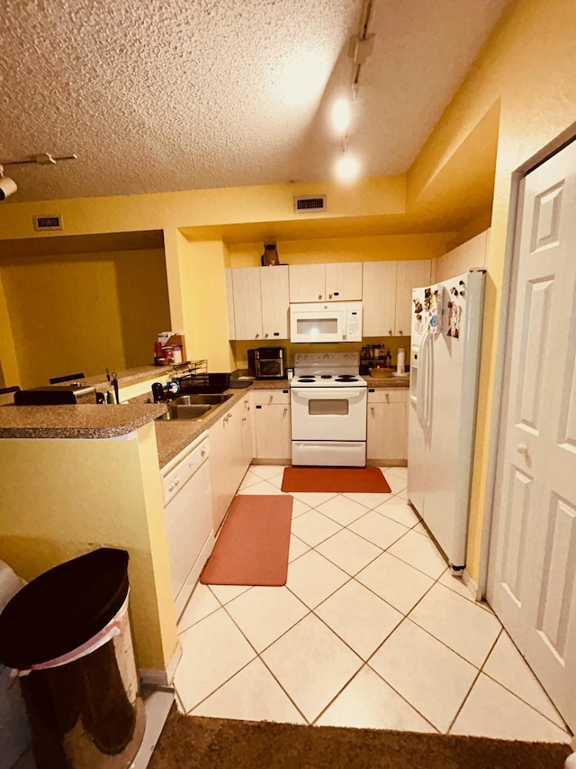 kitchen featuring sink, white appliances, track lighting, white cabinets, and kitchen peninsula