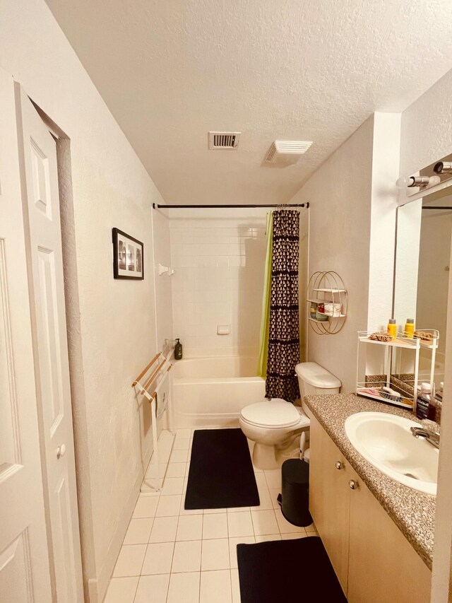 full bathroom with shower / tub combo with curtain, tile patterned flooring, vanity, toilet, and a textured ceiling