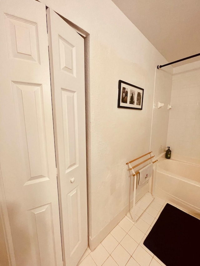 bathroom featuring washtub / shower combination and tile patterned flooring