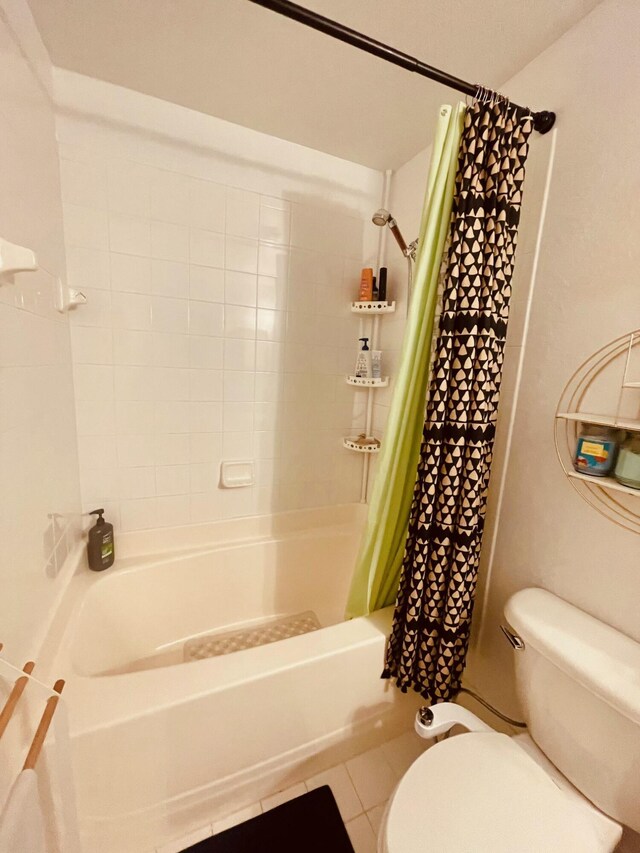 bathroom featuring shower / tub combo, tile patterned flooring, and toilet