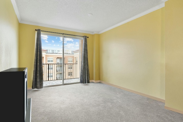 carpeted spare room with ornamental molding and a textured ceiling