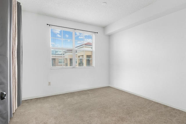 carpeted empty room with a textured ceiling